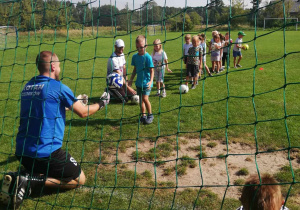 Dzieci z grupy "Skrzatów" strzelają piłką do bramki.