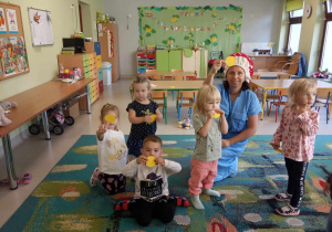 Ciocia Iwonka wraz z dziećmi z grupy "Żabek" z wyciętymi, kolorowymi kółkami.