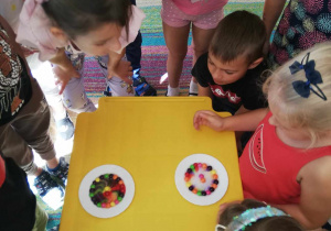 Dzieci z grupy "Skrzatów" porównują kolorowe cukierki w zimnej i ciepłej wodzie.