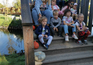 Dzieci wraz ze swoimi nauczycielkami na schodach podczas pamiątkowego zdjęcia.