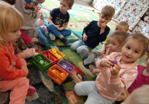 Kilkoro dzieci z grupy "Żabek" segreguje owoce i warzywa ze względu na kolor.