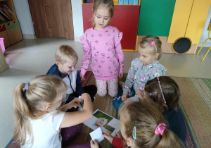 Kilkoro dzieci ze "Skrzatów" składa w całość i nakleja na kartkę ilustrację chomika.