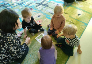 Kilkoro dzieci z "Żabek" składa w całość i nakleja na kartkę ilustrację chomika.