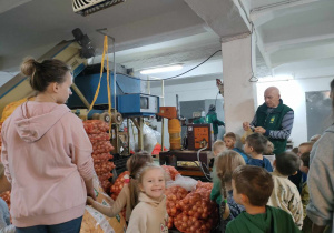 Pan Prezes GS Ozorków prezentuje dzieciom maszynę do ziemniaków.