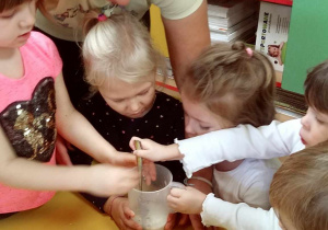 Dzieci wraz z jedną z Mam - p. Eweliną Matusiak podczas mieszania składników na ciasto.