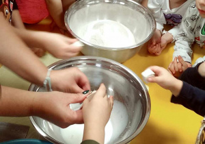 Dzieci wspólnie przygotowują mieszankę do przygotowania ciasta na bułeczki.