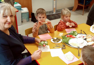 Pani Dyrektor wraz z kilkoma dziećmi z grupy "Motylków" podczas degustacji zdrowego śniadania.