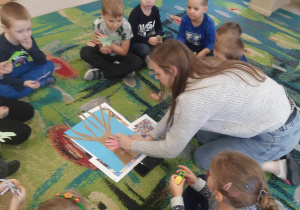 Ciocia Daria wraz z dziećmi podczas tworzenia wspólnej pracy plastycznej - "Drzewo praw dziecka".