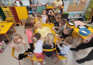 Dzieci z grupy "Motylków" podczas formowania ciasta na bułeczki.