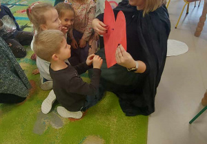 Dzieci z Biedronek w trakcie zabawy w przebijanie wielkiego, czerwonego serca, na odwrocie którego są wypisane różne imiona.