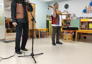 Panowie prowadzący prezentują dzieciom instrument muzyczny - charango.