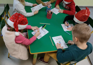 Kilkoro dzieci z grupy Pszczółek rysują to, co chciałyby otrzymać od Świętego Mikołaja oraz próbują się podpisać.
