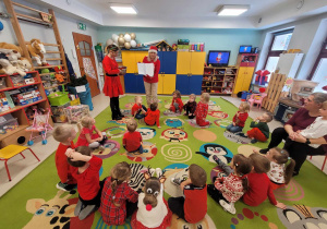 Wizyta p. Dyrektor oraz p. Intendent w sali Motylków. P. Dyrektor prezentuje dzieciom świąteczną kolorowankę.