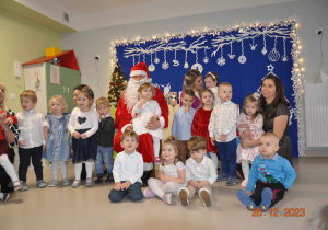 Pamiątkowe zdjęcie dzieci z grupy "Żabek", cioci Iwonki, p. Dyrektor oraz Świętym Mikołajem.