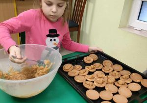 "Szarlotka Misia Puchatka" - wspólne przygotowanie zdrowego deseru. Zuzia nakłada tarte jabłuszka łyżką na biszkopty.