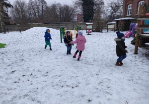 Zabawa w "berka" - Kajtek jest "berkiem" i goni pozostałe dzieci na przedszkolnym ogrodzie.