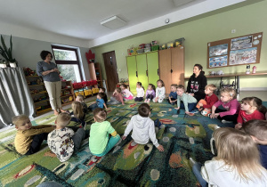 Dzieci z młodszych grup słuchają informacji dotyczących zdrowego odżywiania.