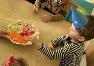 Dzieci częstują się zdrowymi smakołykami - warzywami.