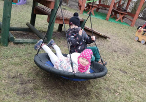 Roksana i Leon na bocianim gnieździe na przedszkolnym placu zabaw.