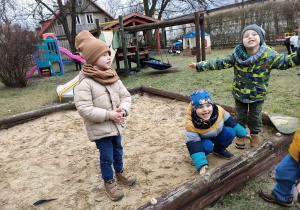 Antoś, Szymon i Filip w piaskownicy na przedszkolnym placu zabaw.