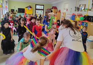 Pani Alicja Reurowicz tańczy z dziećmi do muzyki na balu karnawałowym.