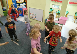 Dzieci na dywanie podczas zabawy ruchowej - "Tańczymy na lodzie" do piosenki "Mam tę moc".