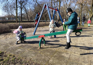 Dwoje dzieci z grupy najstarszej na konikach na placu zabaw w Parku Miejskim.