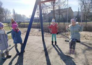 Kilkoro dzieci z grupy "Skrzatów" na huśtawkach na placu zabaw w Parku Miejskim.