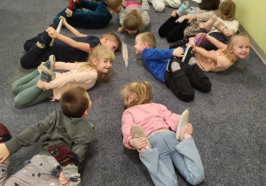 Dzieci na dywanie podczas zabawy ruchowej.