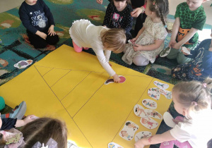 Dzieci z grupy "Żabek" umieszczają ilustrację owoców i warzyw na właściwym szczebelku piramidy żywienia.