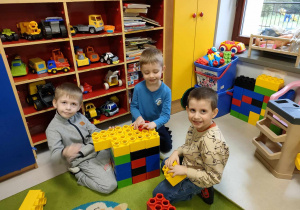 Leoś, Kajtuś i Antoś z "Pszczółek" budują razem z ogromnych, kolorowych klocków LEGO.