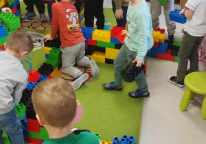 Zabawy konstrukcyjne przy użyciu ogromnych, kolorowych klocków LEGO wśród dzieci z grupy "Biedronek".