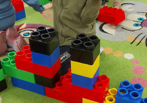 Cyprianek z "Biedronek" bawi się ogromnymi, kolorowymi klockami LEGO.