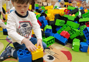 Wojtuś z "Motylków" buduje swoją konstrukcję z klocków LEGO.