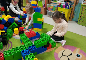 Dziewczynki z "Motylków" tworzą budowle z ogromnych, kolorowych klocków LEGO.