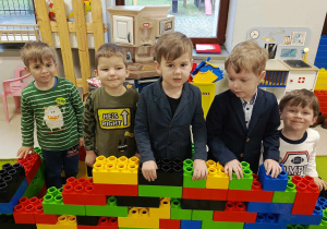 Pięcioro dzieci z "Motylków" wspólnie zbudowało kolorowy mur z klocków.