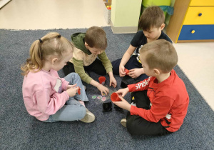 Dzieci w grupach ozdabiają swoje doniczki, przy wykorzystaniu wiosenno-wielkanocnych naklejek.
