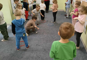 Ciocia Justynka tłumaczy dzieciom zasady zabawy orientacyjno-porządkowej - "Zajączki w norce".