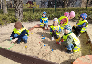 Zabawa w piaskownicy na terenie placu zabaw w Parku Miejskim.