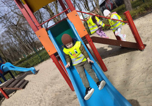 Franuś zjeżdża ze zjeżdżalni na placu zabaw w Parku Miejskim.