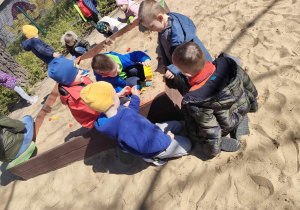 Chłopcy bawią się w piaskownicy.