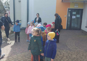 Ciocia Ania tłumaczy zasady poszukiwania schowanej niespodzianki w ogrodzie przedszkolnym.