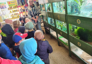 Dzieci oglądają różne rybki w akwariach.