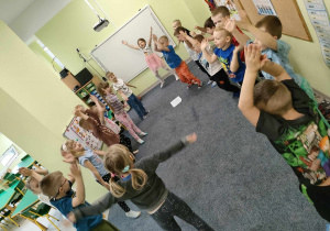 Dzieci z grupy "Pszczółek" podczas rozgrzewki w myśl hasła programowego - "Aktywność ruchowa - potrzebna i zdrowa".