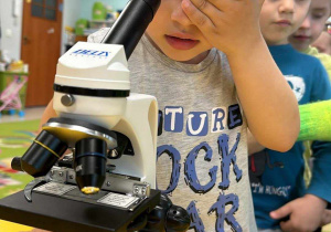 Chłopiec z "Żabek" korzysta z mikroskopu.