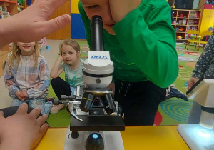 Szymon korzysta z mikroskopu.