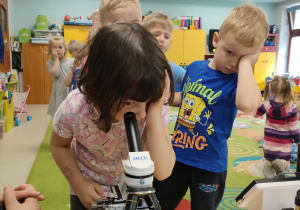Ala korzysta z mikroskopu.