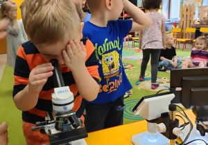 Natan korzysta z mikroskopu.