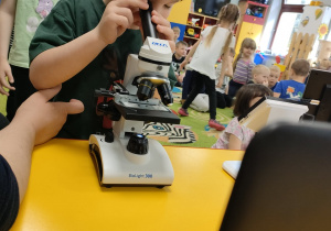 Adam korzysta z mikroskopu.