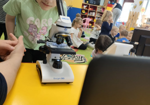 Oliwia korzysta z mikroskopu.